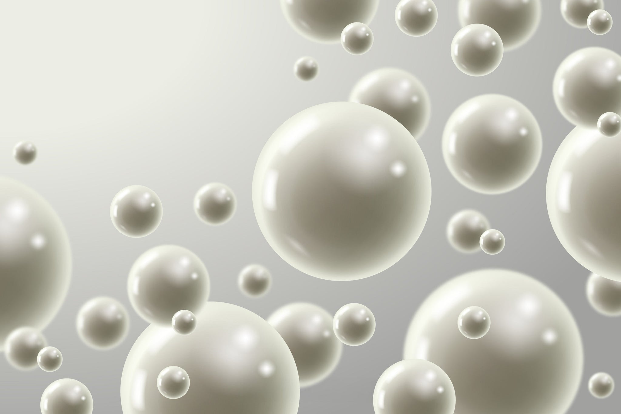 3D rendering of smooth white spherical particles of different sizes floating against a gray background, representing microspheres or polymer beads